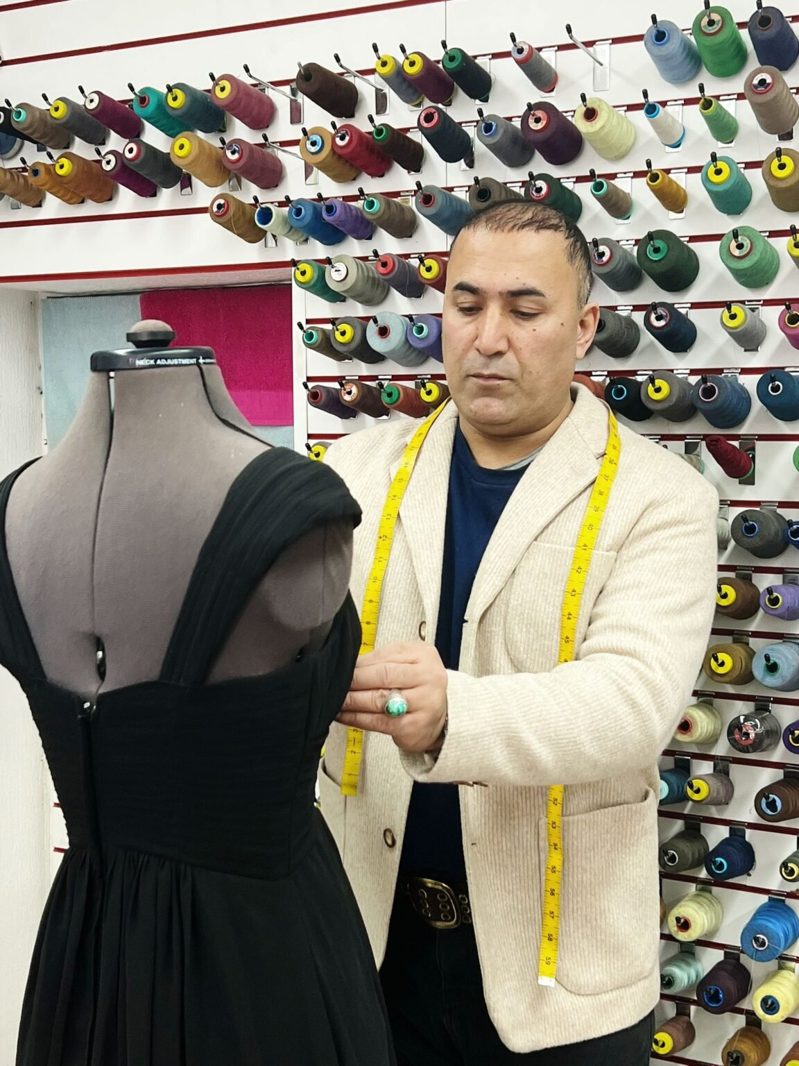 sewseam tailor taking size of a dress at sewseam shop - your best suit alterations shop